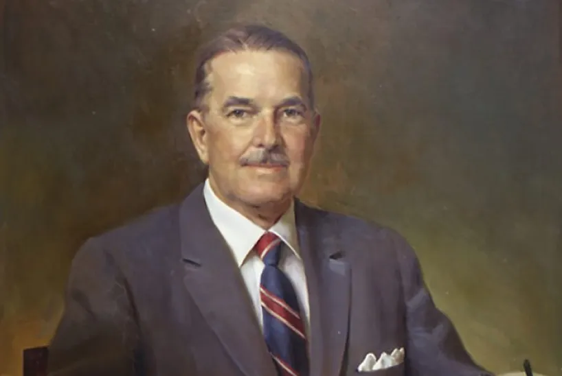 A painted portrait of a middle-aged man with neatly combed hair and a mustache, wearing a dark suit, striped tie, and white pocket square, seated against a muted background.